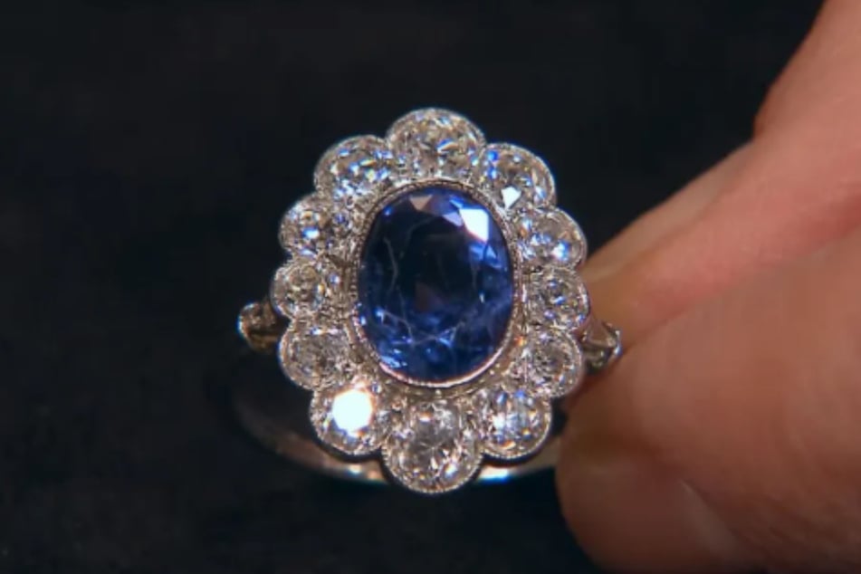 Der Entourage-Ring überzeugt durch einen kornblumenblauen Saphir und eine Vielzahl reiner Diamanten.