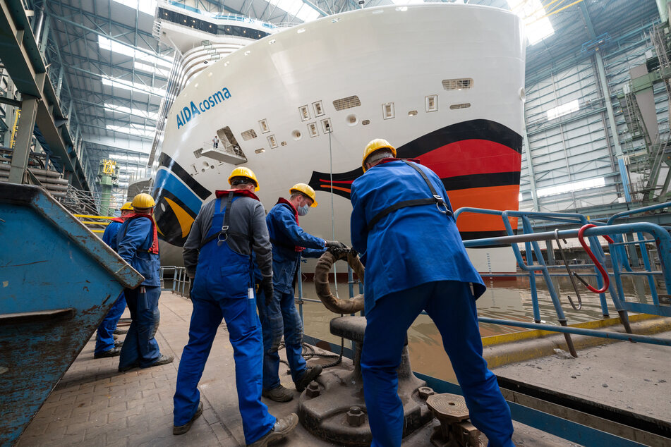 Arbeiter stehen vor dem Bug der "Aida Cosma". Das Kreuzfahrtschiff ist 337 Meter lang.