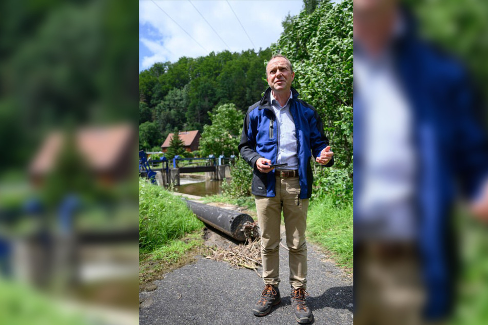 Vor dem Wehr in Porschdorf versuchte sich Umweltminister Wolfram Günther (Grüne) am Montag an einer ersten Schadensbilanz.