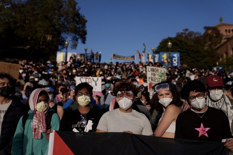 Pro-Palestinian protestors stand on stairs near an encampment at the UCLA campus on May 2, 2024.