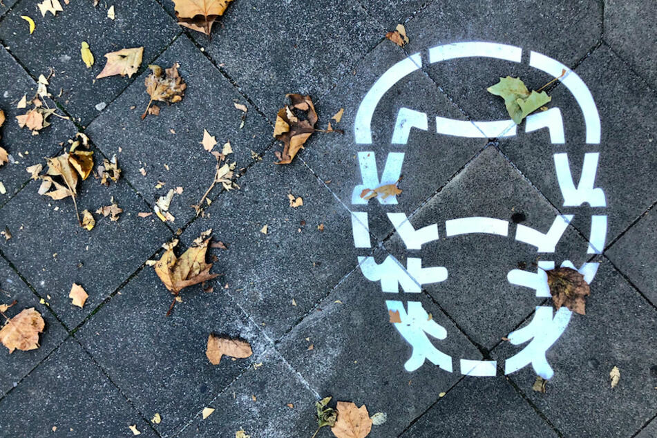 Eine Bodenmarkierung verweist auf die Maskenpflicht.