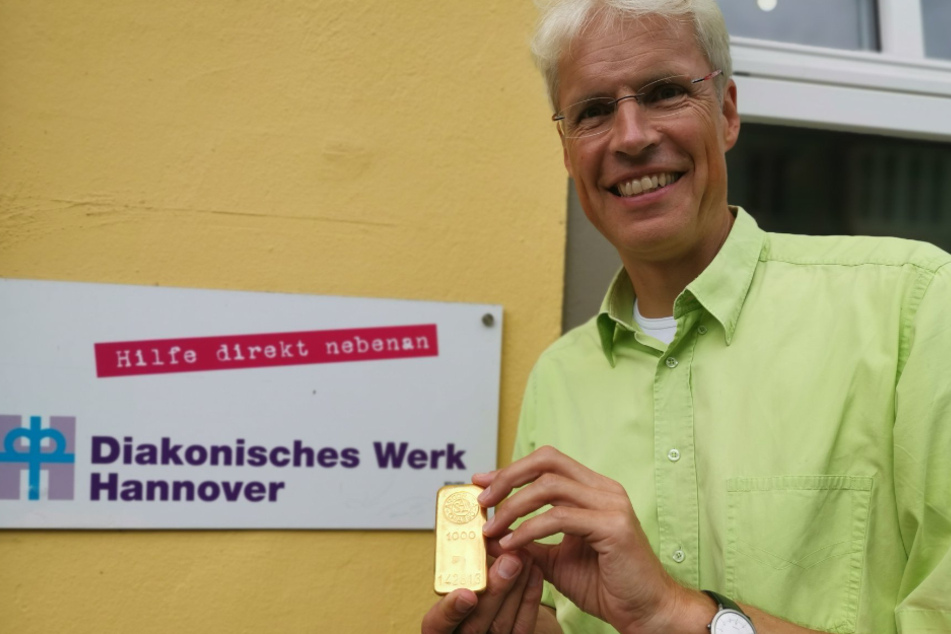Ein Mitarbeiter hält den Goldbarren, welcher von einer älteren Dame gespendet wurde.