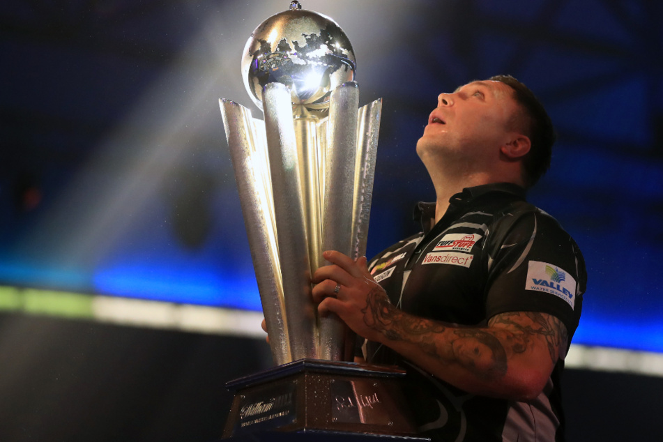 Der neue Weltmeister Gerwyn Price aus Wales hält seine Trophäe fest.