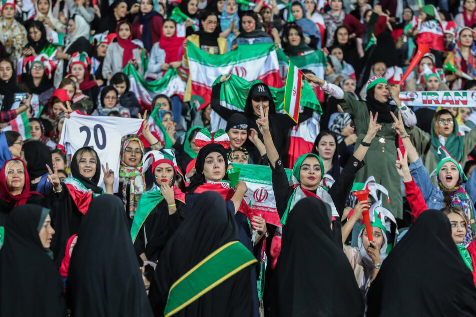 Frauen jubeln auf der Tribüne im Asadi-Stadion während eines Fußball-Spiels.