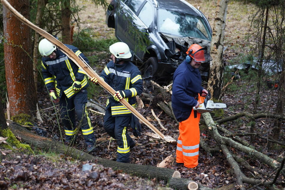 Mit Kettensägen beseitigte die Feuerwehr störende Baumstämme, die sonst die Bergung des Autos behindert hätten.