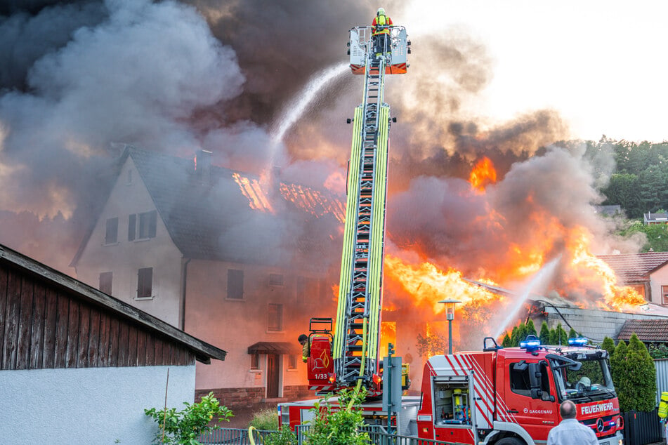 Inferno in ehemaligem Holzbetrieb: Flammen schlagen auf Wohnhaus über, 25 Menschen evakuiert