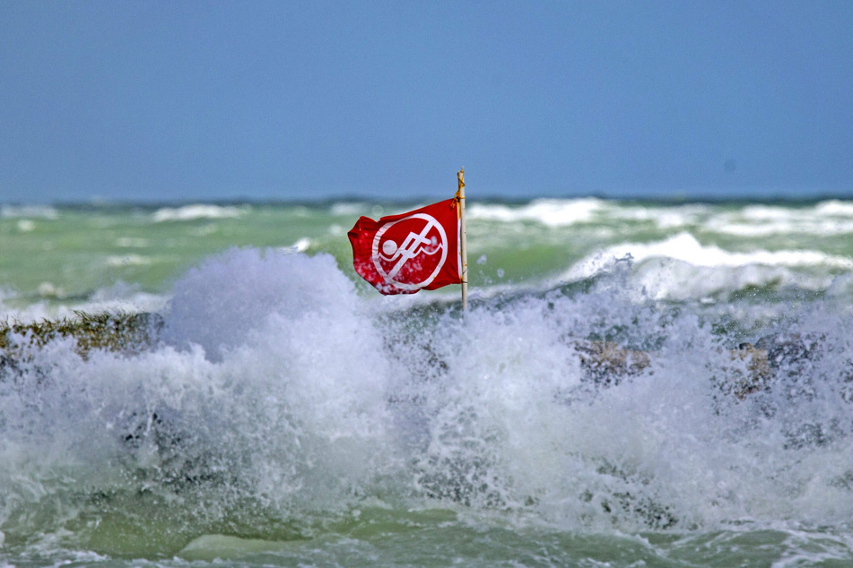 A red current advisory flag in Miami Beach, Florida flaps in the wind, indicating the ocean current is strong and not swimmable for the day.