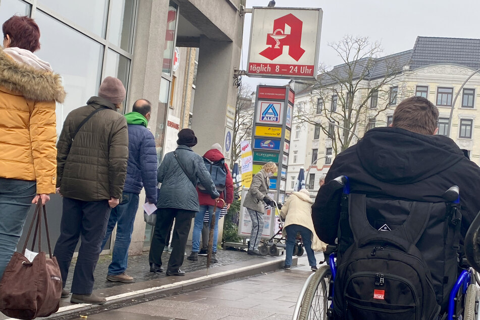 Kunden warten vor einer Apotheke in Hamburg. Menschen ab 60 Jahren und Personen mit bestimmten chronischen Erkrankungen können ab Dienstag drei FFP2-Masken kostenlos in Apotheken erhalten.