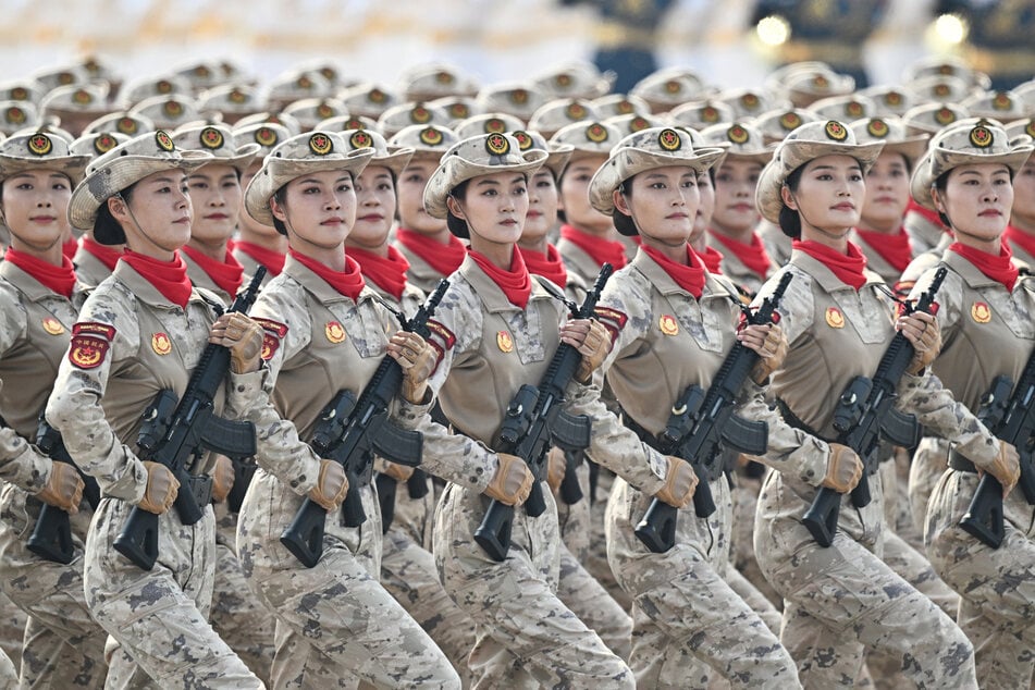 Chinesische Soldatinnen marschieren in Formation über den Platz des Himmlischen Friedens in Peking.