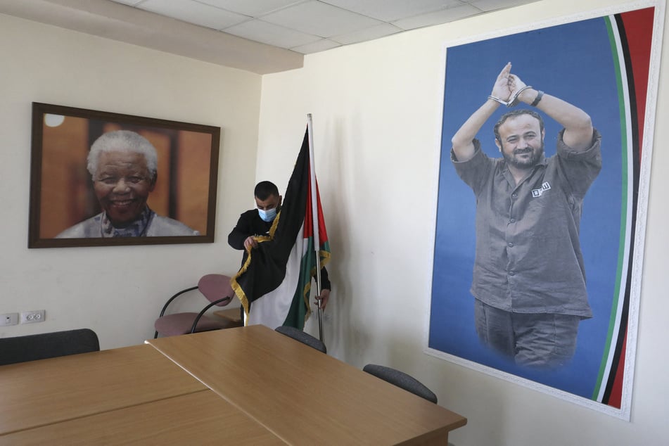 A portrait of the late South African President Nelson Mandela (l.) hangs next to one of Palestinian political leader Marwan Barghouti at an office in the West Bank city of Ramallah on March 3, 2021.
