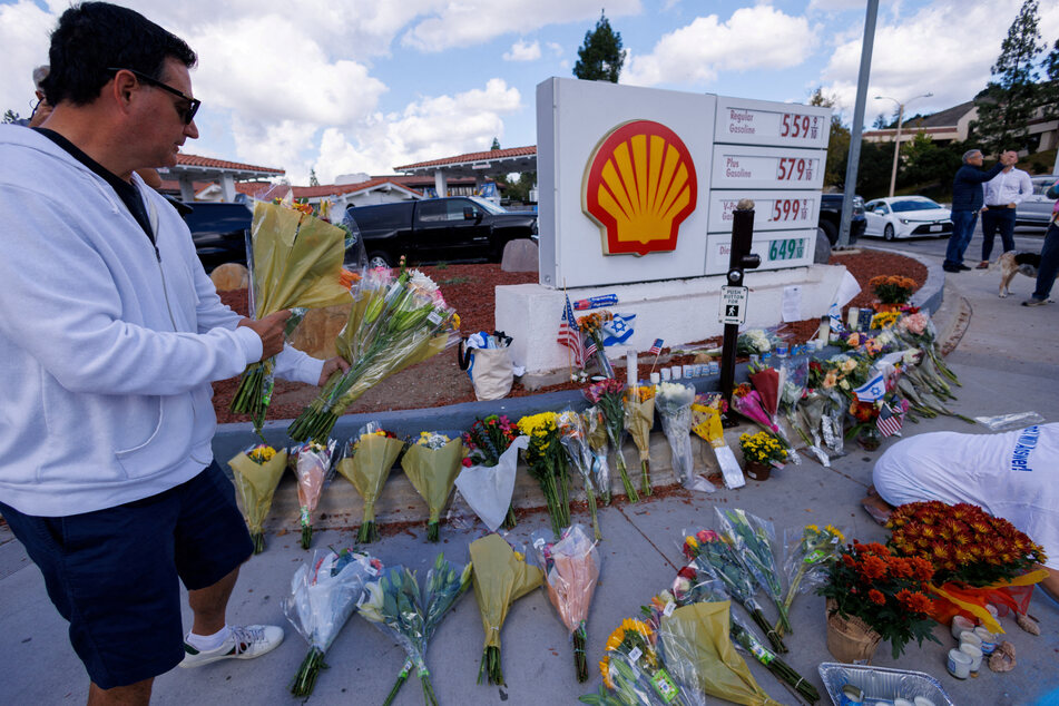 A man brings flowers to the exact location on the sidewalk of the alleged assault on Paul Kessler in Thousand Oaks, California.