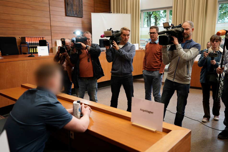 Medienvertreter filmen im Landgericht Traunstein den Angeklagten, der 2022 eine 23-Jährige auf dem Heimweg von der Diskothek "Eiskeller" in Aschau im Chiemgau getötet haben soll.