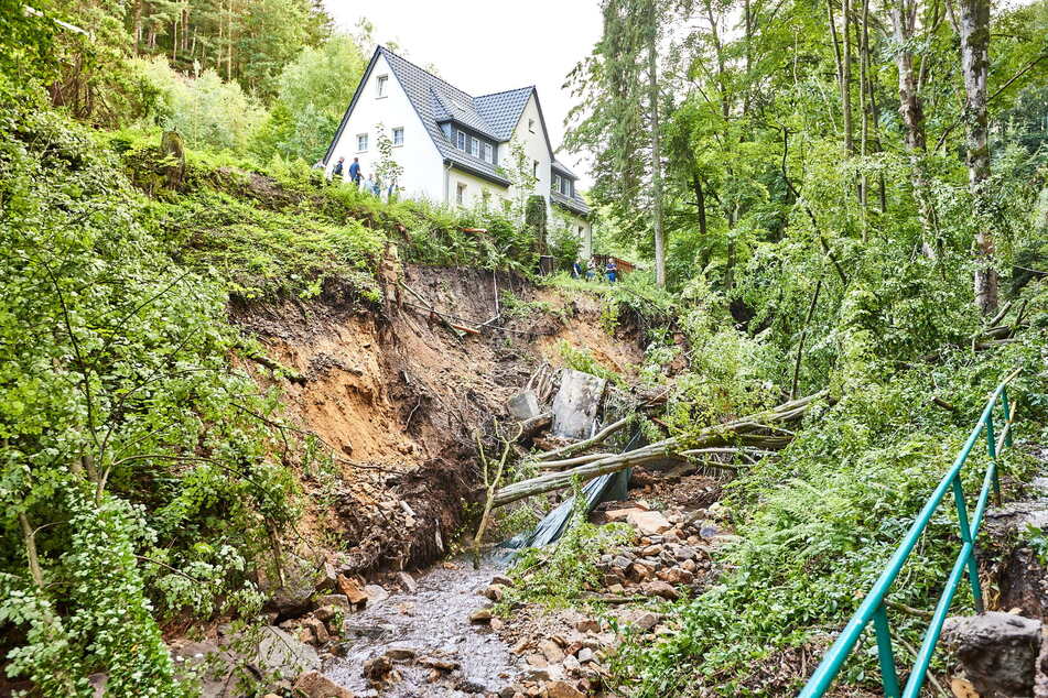 Im Hirschgrund droht dieses Haus den Hang hinunterzustürzen. Einsatzkräfte versuchen, es zu sichern.