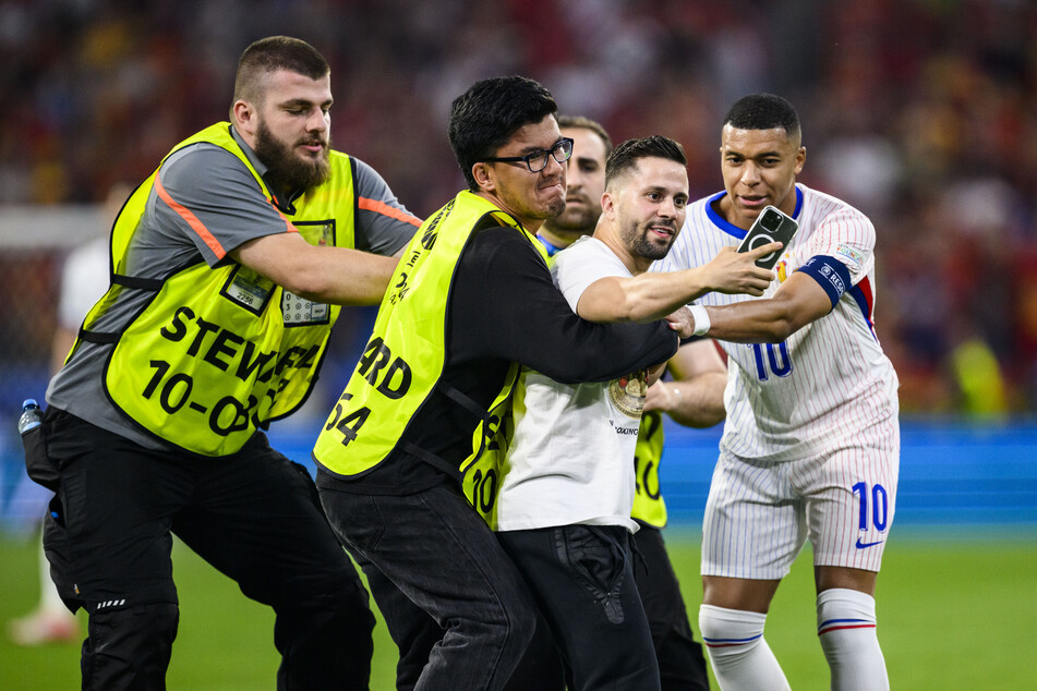 Beim Halbfinale zwischen Frankreich und Spanien hatten die Ordner alle Hände voll zu tun. Mehrere Flitzer wollten ein Selfie mit Superstar Kylian Mbappé (25, r.) knipsen.