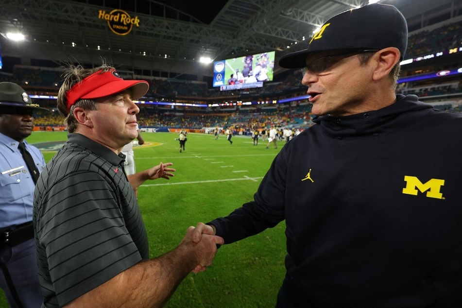 Michigan coach Jim Harbaugh (r.) has recently added a "Beat Georgia" period to team practice, but fans are questioning the move after its most recent lost to TCU.
