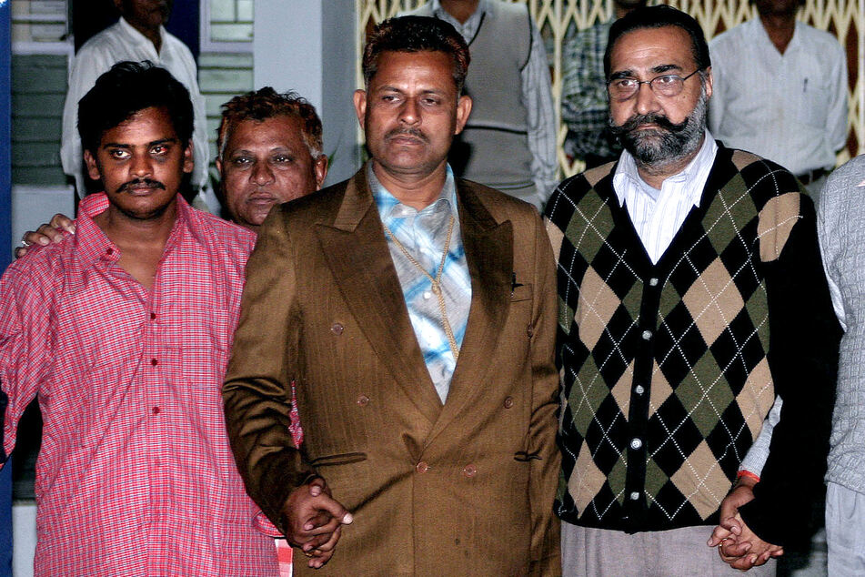 Hausdiener Surinder Koli (heute 40, l.) und sein ehemaliger Chef Moninder Singh Pandher (heute 65, r.) nach ihrer Festnahme im Dezember 2006, eingerahmt von Ermittlern.
