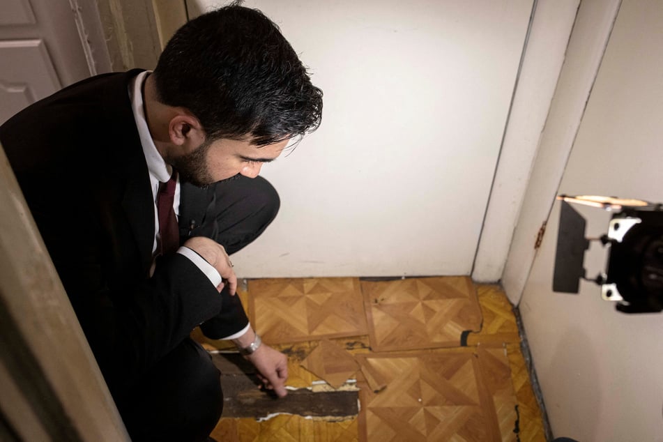 New York City Mayor Zohran Mamdani inspects the floor as he visits an apartment owned by the Pinnacle Group on his first day in office on January 1, 2026.