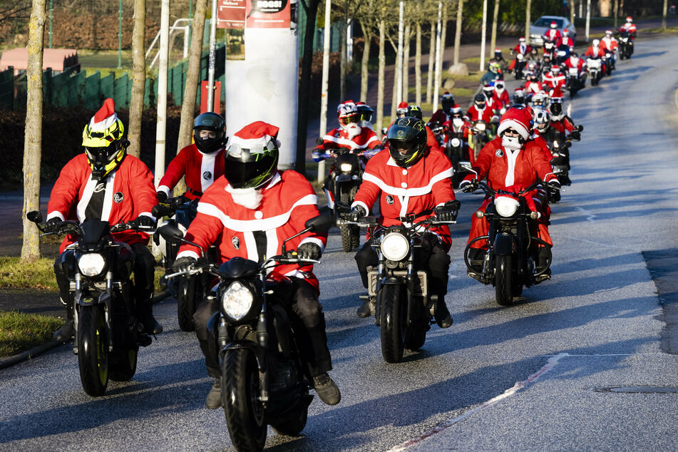 Biker fahren verkleidet als Weihnachtsmänner durch den Stadtteil Wellsee.