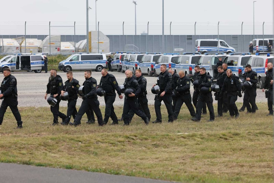 Die Polizei überwacht das Geschehen mit zahlreichen Einsatzkräften und Fahrzeugen.