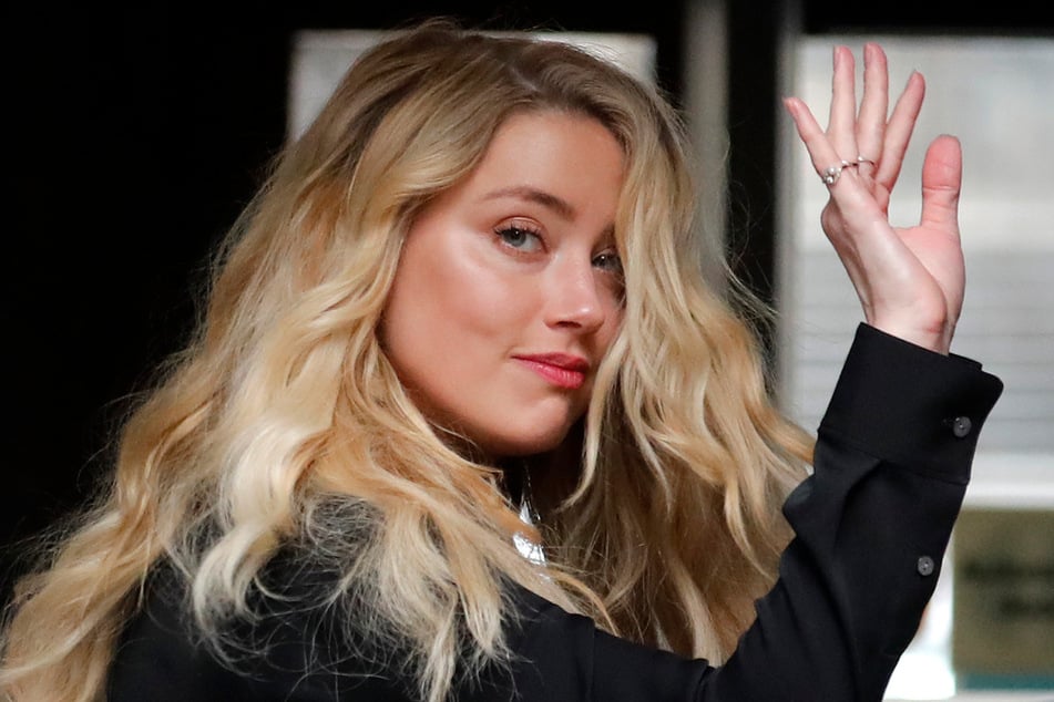 Die US-amerikanische Schauspielerin Amber Heard (34) winkt am Dienstag bei ihrer Ankunft in London am High Court .