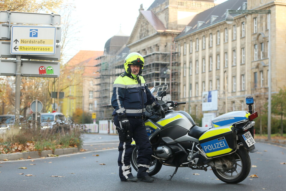 Ein Motorrad-Polizist sichert nach der Bombendrohung das Oberlandesgericht in Düsseldorf.