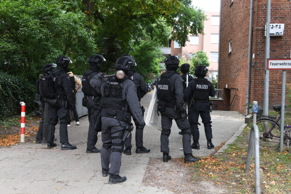 Beamte der Spezialeinheit USE bringen sich vor dem Haus in Position.