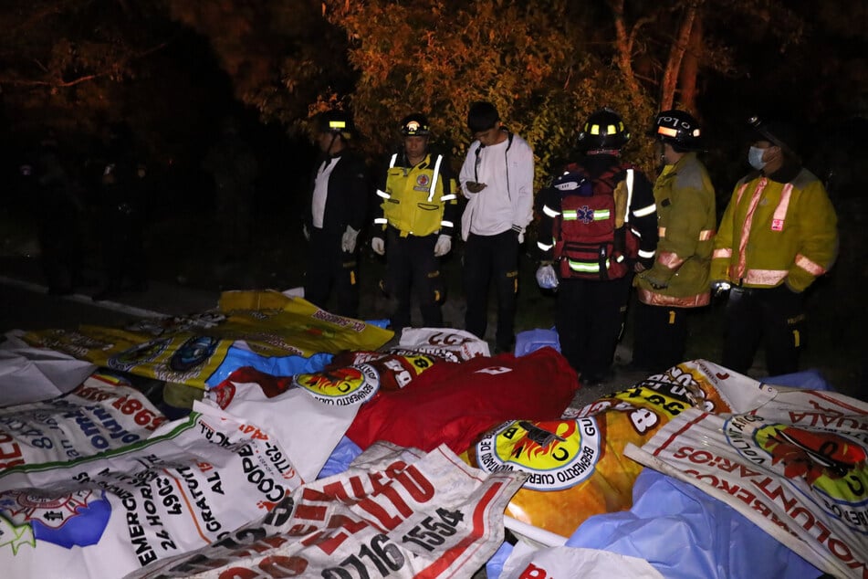 Die Einsatzkräfte stehen vor den Todesopfern.