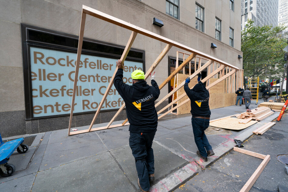Die Fenster eines Lego-Geschäftes im Rockefeller Center in New York werden von Arbeitern mit Holzplatten aus Angst vor Beschädigungen bei möglichen Ausschreitungen rund um die US-Präsidentschaftswahl geschützt.
