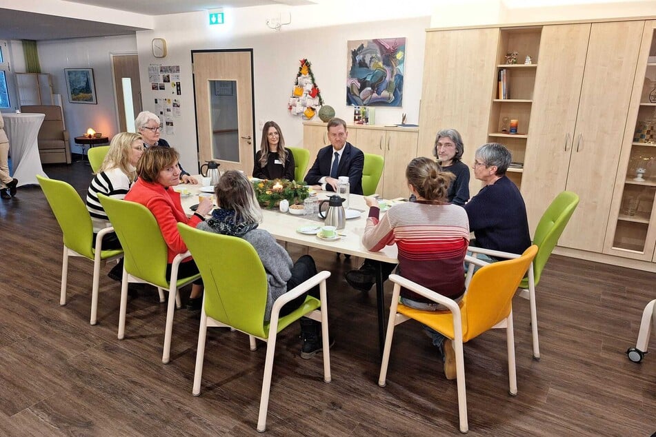 Nach dem Rundgang aßen Schwester Beatrix Lewe (l.), Geschäftsführerin Ivonne Hentschke (2.v.l.o.), Michael Kretschmer (im Anzug), Schirmherrin Prof. Dr. Christine Langenfeld (in Rot), Herr Mattukat sowie weitere Mitarbeiterinnen des Hospizes die im Haus gebackene Eierschecke.