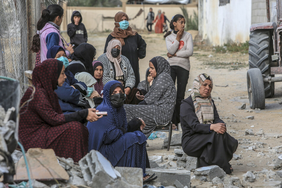 Palästinensische Frauen sitzen nach einem israelischen Luftangriff um ein zerstörtes Haus einer Familie im südlichen Gazastreifen.
