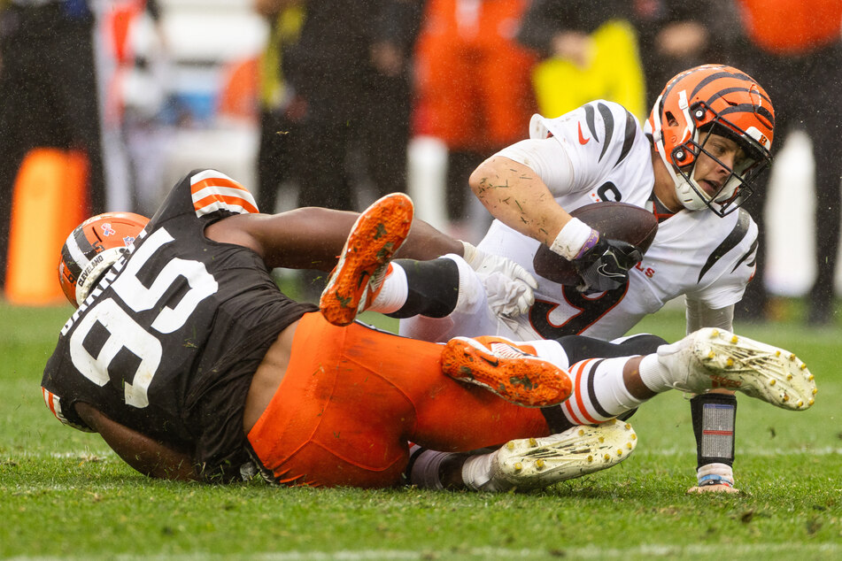 Cincinnati Bengals quarterback Joe Burrow falls as Cleveland Browns defensive end Myles Garrett sacks him during the fourth quarter at Cleveland Browns Stadium.