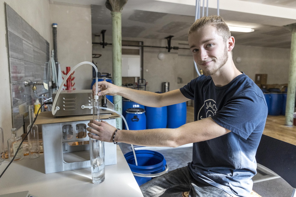 Azubi Linus Kupper (17) füllt den Obstbrand per Hand in jede Flasche ab.