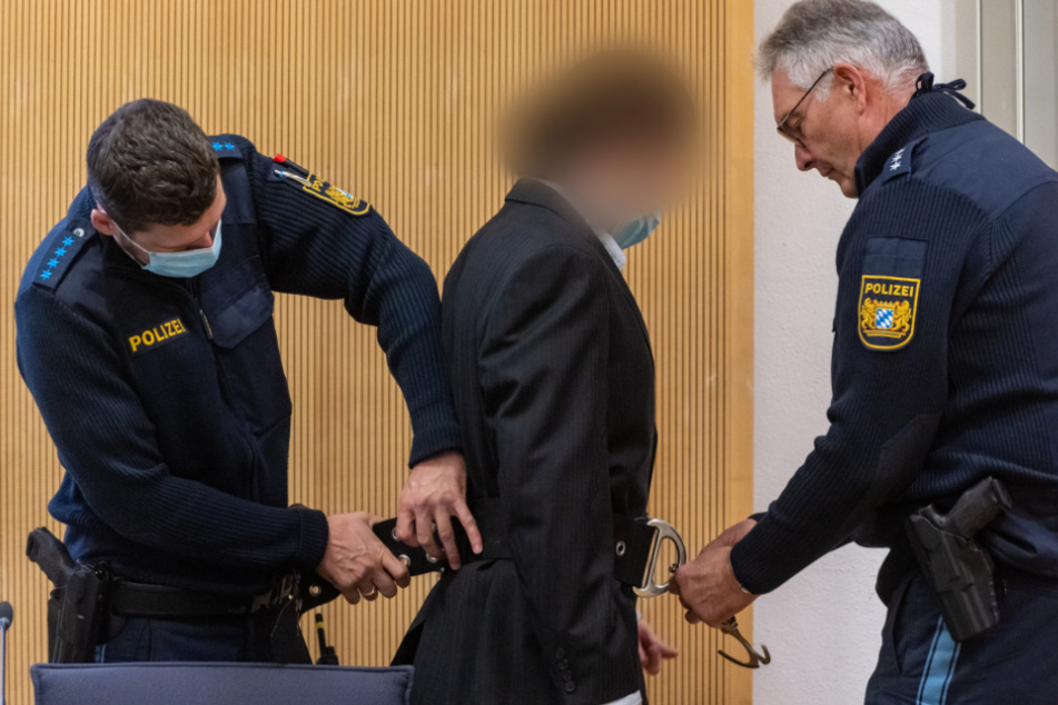 Dem Angeklagten werden im Verhandlungssaal des Landgerichts von Polizisten die Handschellen abgenommen. (Archiv)