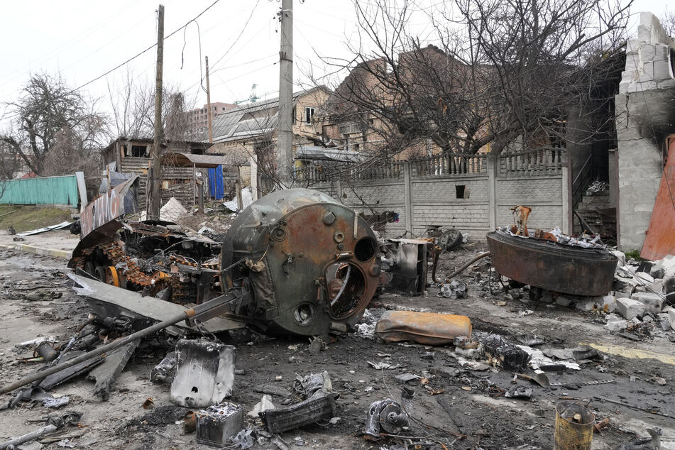 Mitten auf einer Straße in Butscha liegen die Überreste eines russischen Militärfahrzeugs.