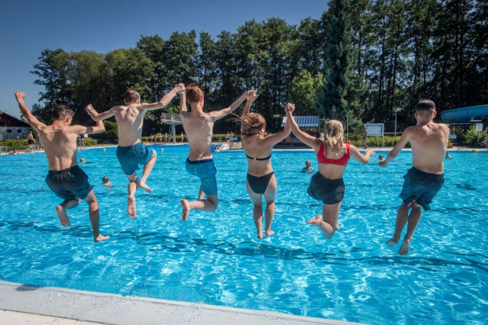 Die Jugendlichen springen ins Wasser.