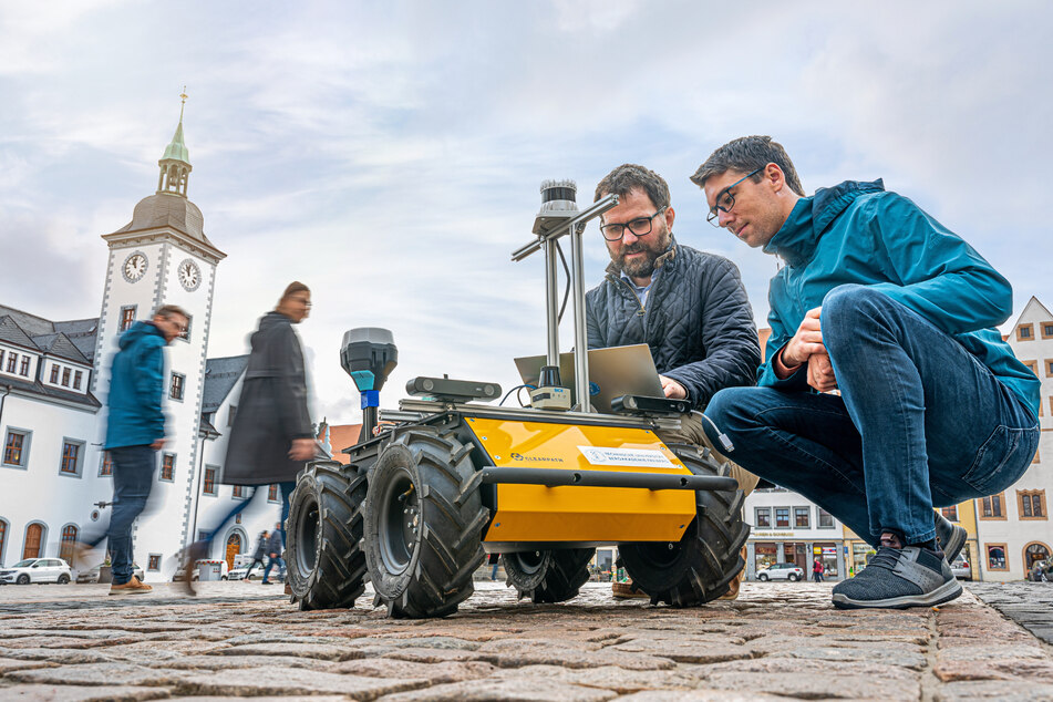 Prof. Dr. Sebastian Zug (47, l.) und sein Mitarbeiter Norman Seyffer testen in der Freiberger Innenstadt Zustell-Roboter "Husky". Sie wollen ermitteln, unter welchen Bedingungen dieser Fuß- und Radwege nutzen kann.