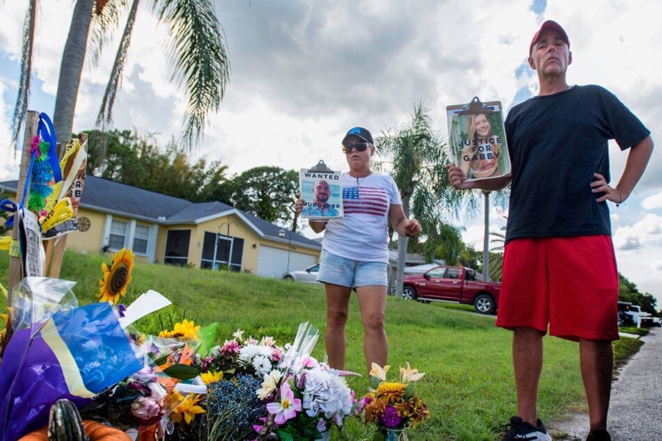 Two protesters stand by a makeshift memorial for Gabby Petito outside Brian Laundrie's parents' home in North Port, Florida on October 6.