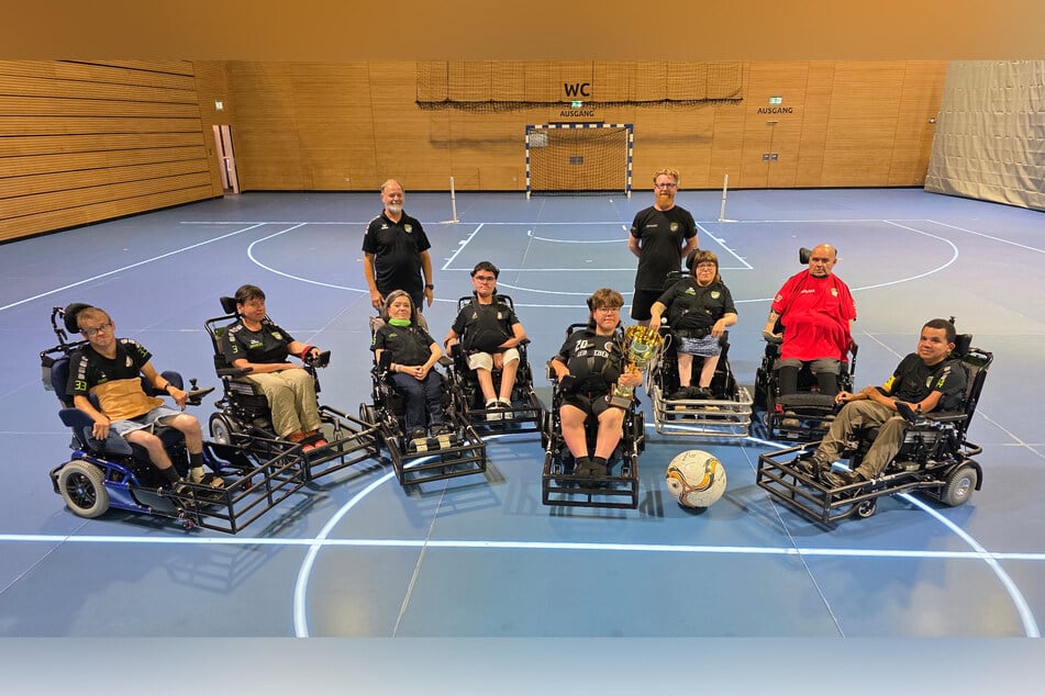 Stolz präsentiert das Team seinen Meisterpokal, der erst im Juni errungen wurde.