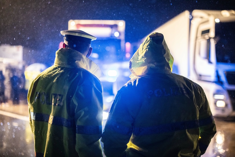 Polizisten kontrollieren einen Lkw an einer Autobahn-Kontrollstelle. (Symbolbild)