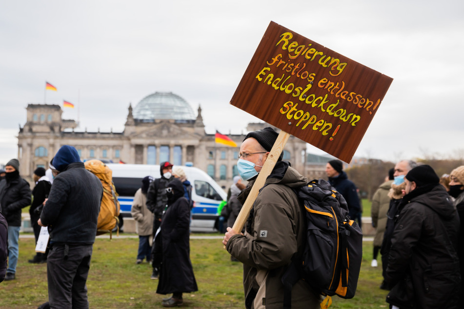 Ein Mann steht bei einer Kundgebung gegen die Corona-Maßnahmen vor dem Reichstagsgebäude