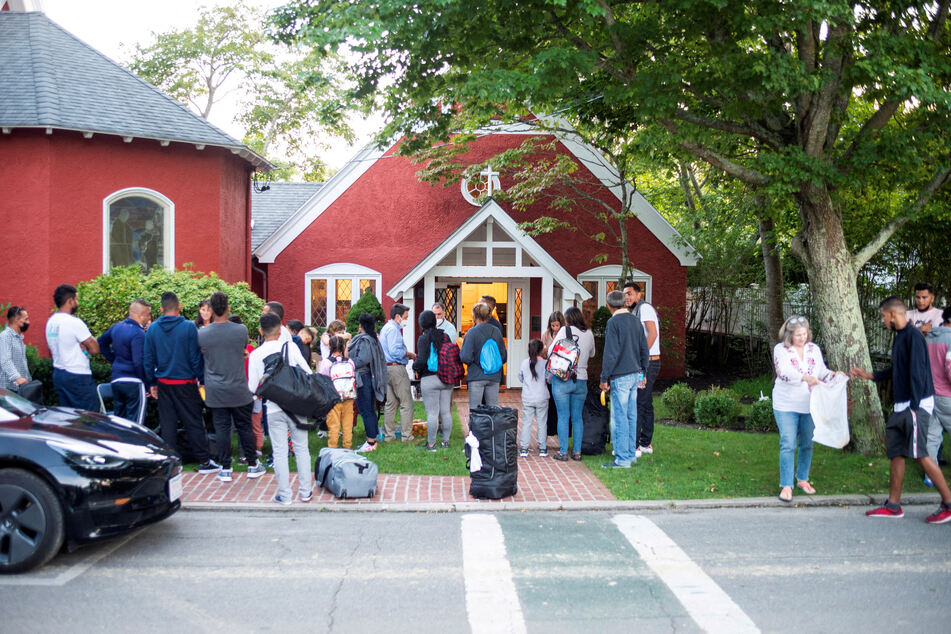 Venezuelan migrants gather outside St. Andrew's Church in Edgartown, Massachusetts