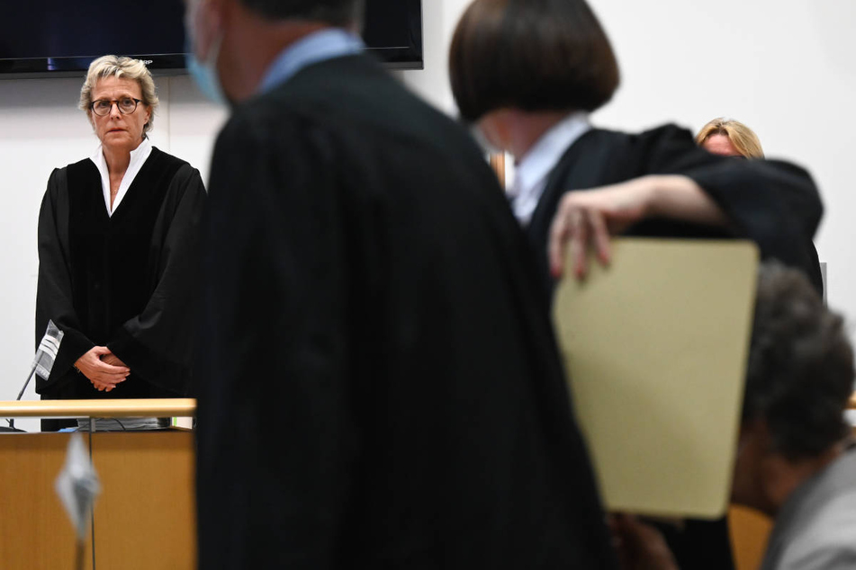 Richterin Susanne Wetzel (l.) sowie die Angeklagte (r., Gesicht verdeckt) mit ihren beiden Verteidigern bei Beginn des Prozesses in Hanau.