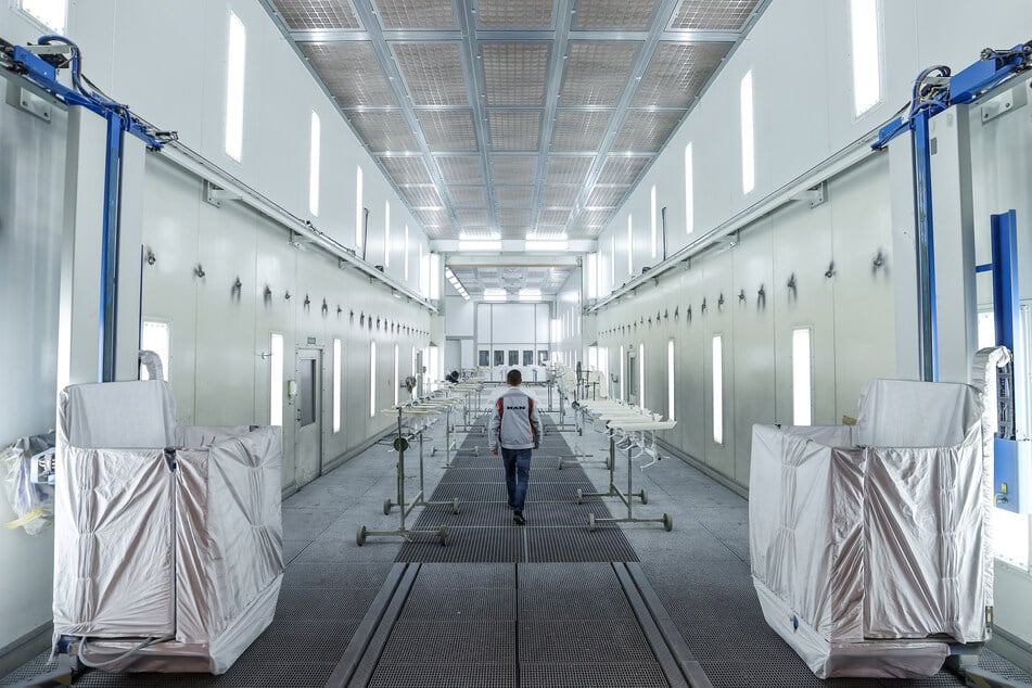 Ein Mitarbeiter des MAN Bus Modification Centers (BMC) geht durch eine der fünf riesigen Lackierkabinen. Die Kabinen sind 6 Meter hoch und breit, 17 Meter lang und fassen einen kompletten Reisebus.