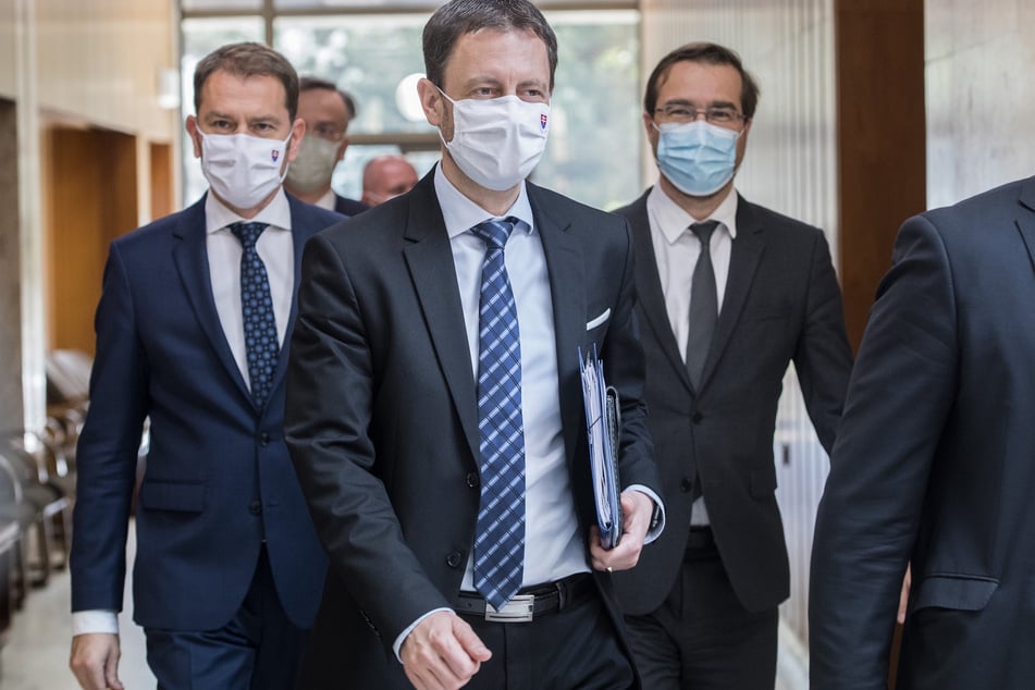 Eduard Heger (l-r), Finanzminister, Igor Matovic, neuer Regierungschef der Slowakei, und Marek Krajci, Gesundheitsminister, gehen zusammen einen Flur entlang.