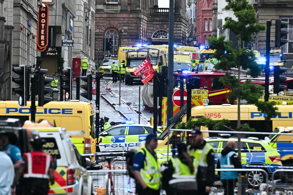 Ambulances and police vans arrive on the scene of an incident in Water Street, on the sidelines of an open-top bus victory parade for Liverpool's Premier League title win, in Liverpool, north-west England on Monday.