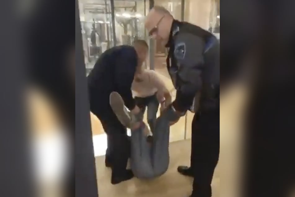 Beamte der Nationalpolizei trugen eine der Aktivistinnen aus dem Museo Naval.