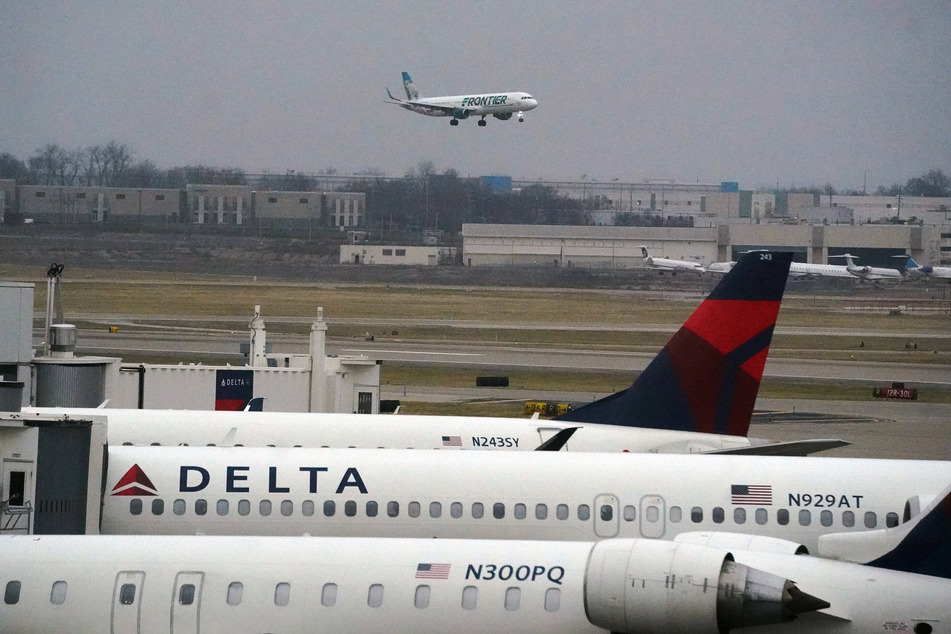 As a Frontier plane landed, Delta planes sat idle at St. Louis-Lambert International Airport on Sunday – just some of the over 4,000 flights that have been delayed or canceled because of the latest Omicron coronavirus surge.