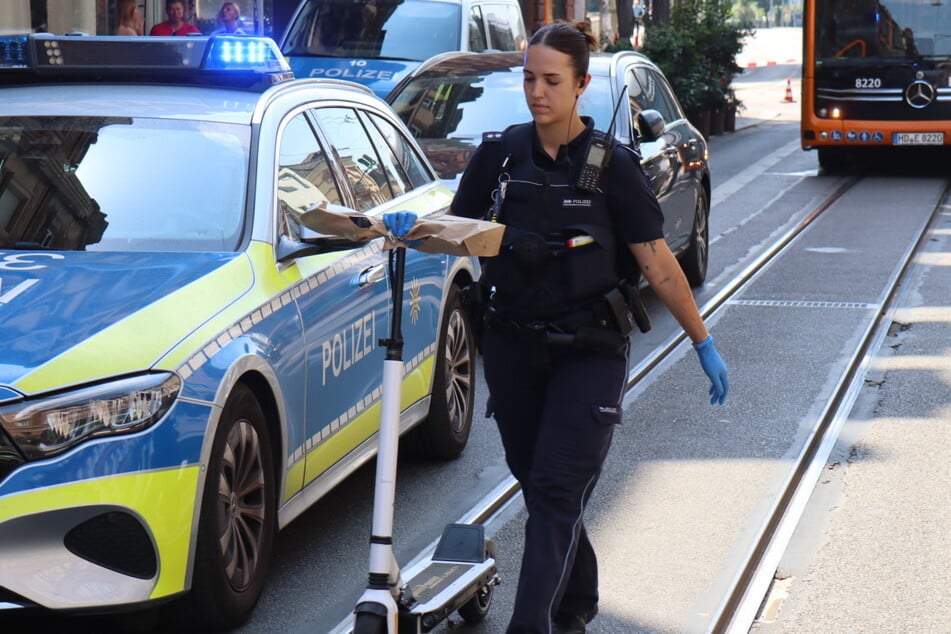 Auf Bildern sieht man, wie eine Beamtin einen E-Roller sicherstellt. Ist der Täter etwa damit zum Tatort gefahren?