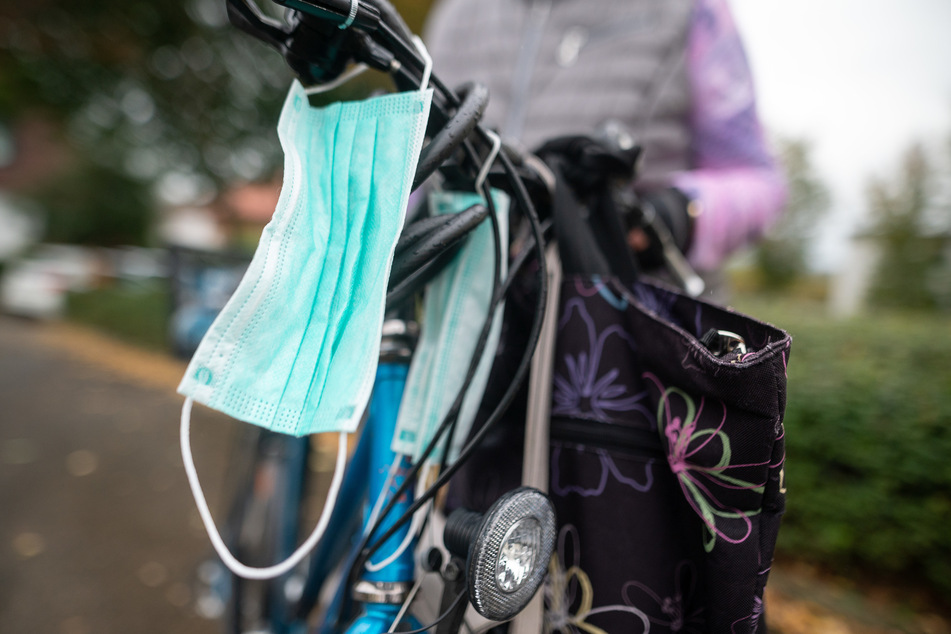 Eine Mund-Nasen-Bedeckung hängt an einem Fahrrad.