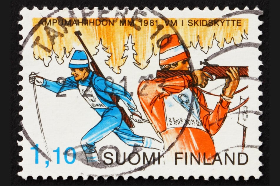 Eine alte Briefmarke aus Finnland von 1981 zeigt zwei Biathleten beim Skilauf und Schießen.